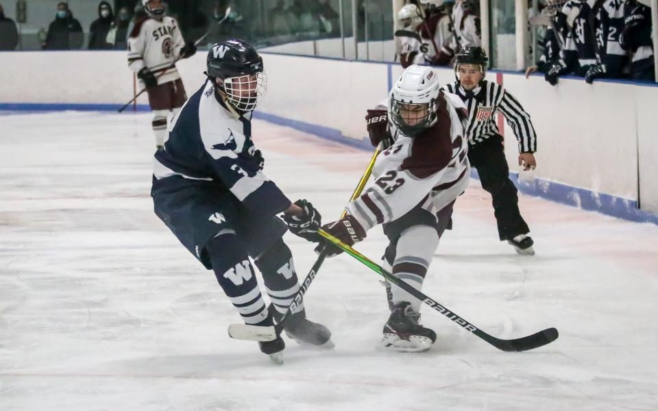 Justin Gouveia of Bishop Stang follows through after firing a shot on net while Nantucket's attempts to block the shot.