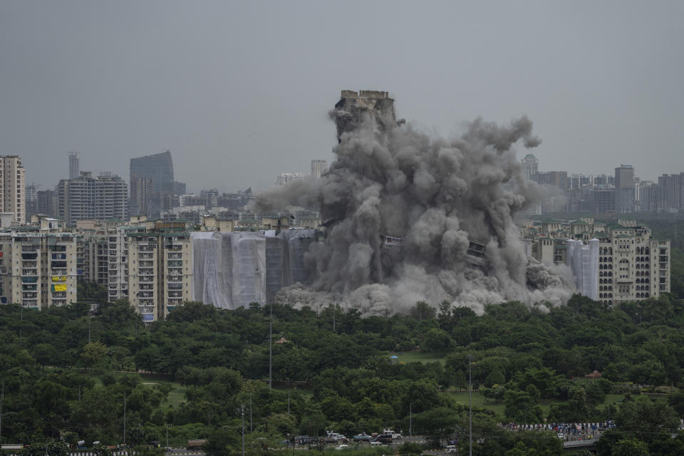 Cloud of dust rises as twin high-rise apartment towers are razed to ground in Noida, outskirts of New Delhi, India, Sunday, Aug. 28, 2022. The demolition was done after the country's top court declared them illegal for violating building norms. The 32-story and 29-story towers, constructed by a private builder were yet to be occupied and became India's tallest structures to be razed to the ground. (AP Photo/Altaf Qadri)