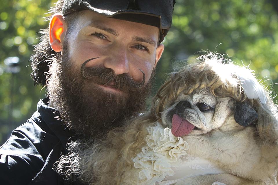 A man poses for a photo with his dog during the 24th Annual Tompkins Square Halloween Dog Parade in New York