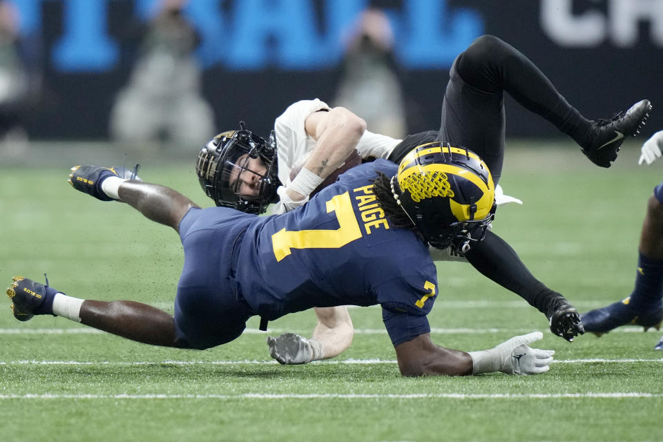 Purdue wide receiver Charlie Jones is stopped by Michigan defensive back Makari Paige (7) during the first half of the Big Ten championship NCAA college football game, Saturday, Dec. 3, 2022, in Indianapolis. (AP Photo/AJ Mast)