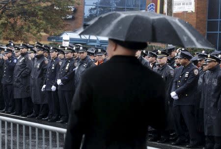 Police officers stand in the rain near the Greater Allen A.M.E. Cathedral of New York during the funeral service for slain New York City Police (NYPD) officer Randolph Holder in the Queens borough of New York City, October 28, 2015. REUTERS/Brendan McDermid