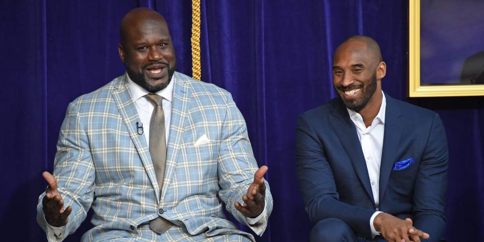 Shaquille O'Neal and Kobe Bryant sit on stage smiling and laughing at an event in 2017.