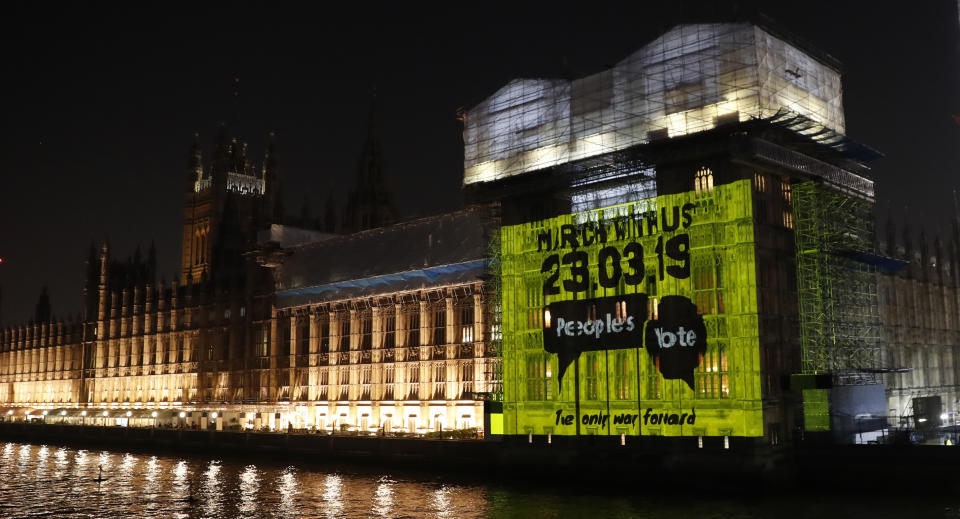 A projection calling for a second referendum or a so-called "Peoples's vote", is cast onto the Houses of Parliament in London, Wednesday Feb. 27, 2019. British Prime Minister Theresa May says she will give British lawmakers a choice of approving her divorce agreement, leaving the EU March 29 without a deal or asking to delay Brexit by up to three months. (AP Photo/Alastair Grant)
