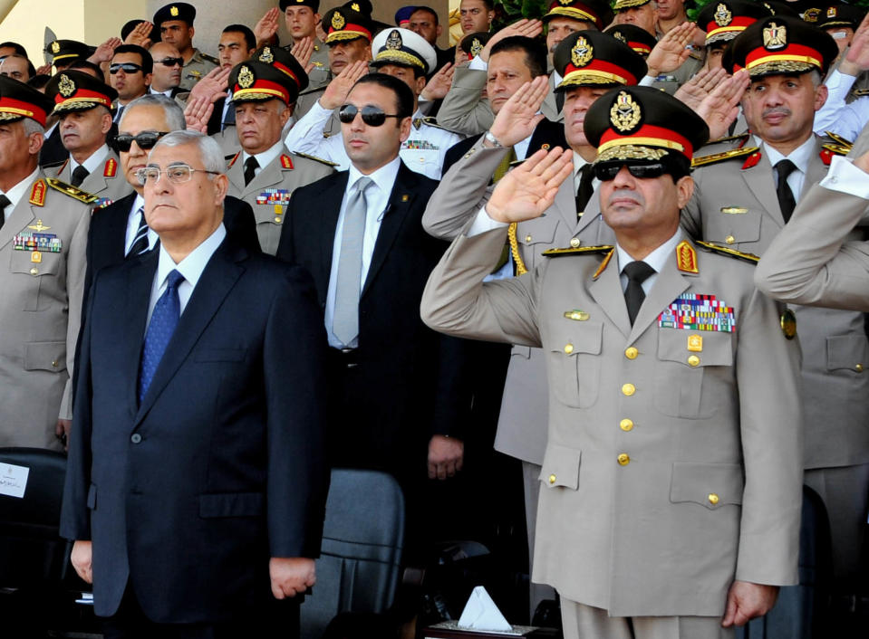 FILE - In this July 22, 2013, file photo released by the Egyptian Presidency, Egypt's interim President Adly Mansour, front left, Defense Minister Gen. Abdel-Fattah el-Sissi, front right, and other military officers listen to the national anthem during a medal ceremony at a military base in eastern Cairo. The militant group Ansar Beit al-Maqdis, which has waged a campaign of bombings and assassinations for months in Egypt, has quickly advanced in weaponry and sophistication of attacks, drawing on the experience of Egyptians who fought in Syria. (AP Photo/Sheriff Abd El Minoem, Egyptian Presidency, File)