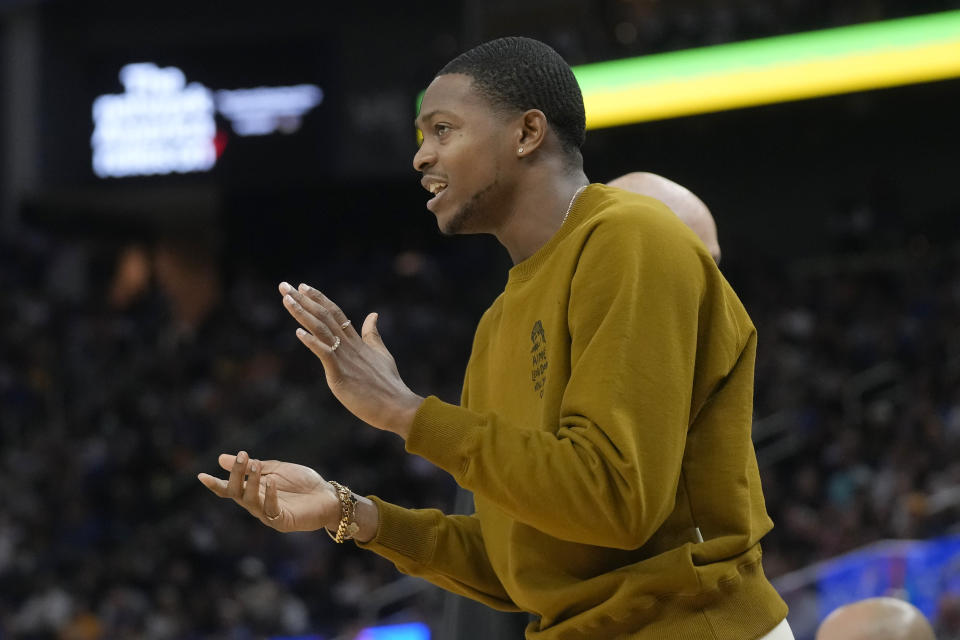 Injured Sacramento Kings guard De'Aaron Fox applauds from the bench during the first half of the team's NBA basketball game against the Golden State Warriors in San Francisco, Wednesday, Nov. 1, 2023. (AP Photo/Jeff Chiu)