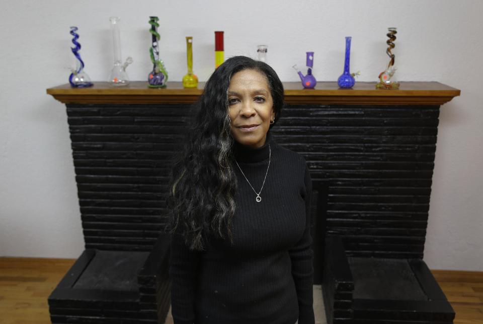 Angel Swanson poses in front of a display of glass pipes at her medical marijuana dispensary in Tacoma, Wash., on Friday, Nov. 15, 2013. Swanson was raised on the South Side of Chicago by a mother who warned: “If you see drugs, run. ”Decades later, the businesswoman and real estate agent found herself in Washington state with a husband, seven children and a strong bias against illegal drugs _ “the poster child for anti-cannabis,” she says. That is, until one of her daughters, who had serious digestive issues and had never weighed more than 100 pounds, came home from college one day and ate a full plate of food. The girl had tried pot-laced cookies, which stimulated her appetite. Swanson lost it. “Do you have any idea the sacrifices that have been made for you to go to college?” she remembers saying. Swanson, 52, did some research and couldn’t find a reason for her daughter not to use weed. She and her husband opened a medical marijuana dispensary, The Cannabis Emporium, near Tacoma. They now want to sell recreational pot, but hope to continue to serve patients _ a challenge, since stores will be barred from trumpeting pot’s therapeutic benefits. (AP Photo/Ted S. Warren)