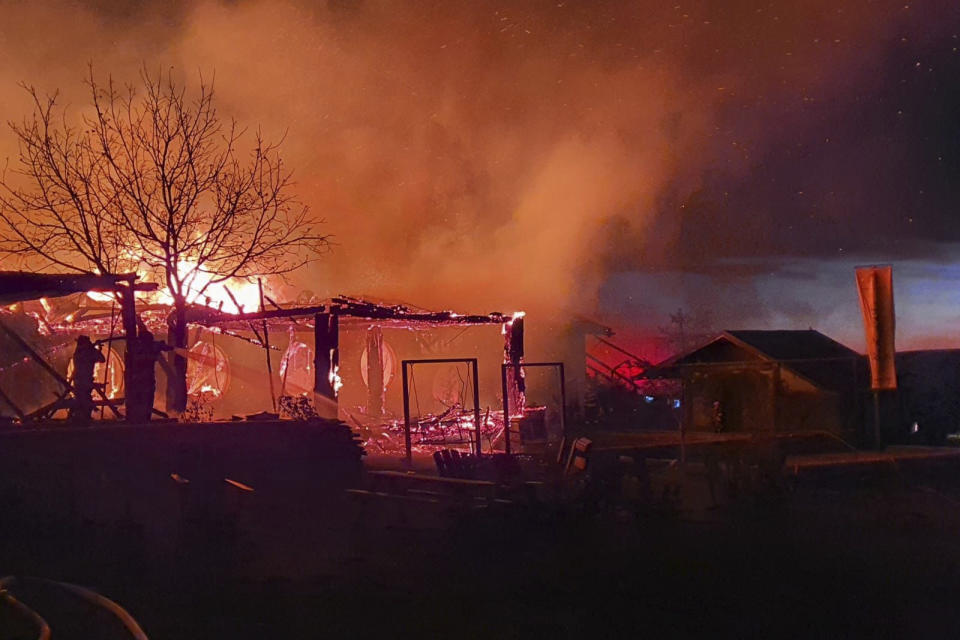 In this photo released by the Romanian Emergency Services Prahova (ISU Prahova), a guesthouse is burning in Tohani, Romania, Tuesday, Dec. 26, 2023. A huge fire at a guesthouse in Romania on Tuesday morning has left several people dead, including a child, and some people are missing, authorities said. (Romanian Emergency Services - ISU Prahova via AP)