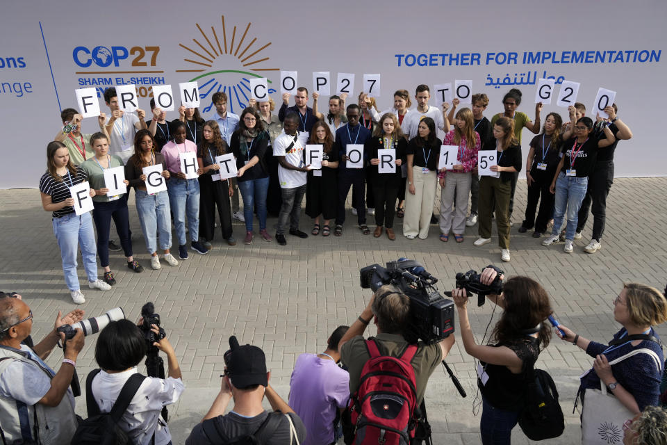 Youth climate activists hold signs that read "from COP27 to G20 fight for 1.5" at the COP27 U.N. Climate Summit, Monday, Nov. 14, 2022, in Sharm el-Sheikh, Egypt. (AP Photo/Peter Dejong)