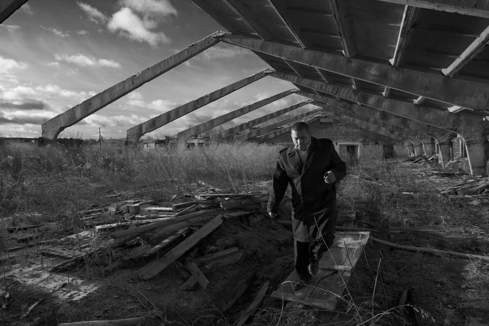 In this Nov. 14, 2012, photo, Eduard Mochalov, editor of The Bribe, walks through a derelict hog barn on his abandoned farm in Yarabaikasy near Cheboksary, the capital city of Chuvashia, Russia. Mochalov has found a new lease on life as a crusading journalist investigating corruption in his native region, fueled by tips from disgruntled businessmen and government workers. Undeterred by a system where the law is selectively used to protect the powerful and crack down on critics, Mochalov has quickly earned cult status _ not to mention the ire of countless local officials _ throughout the small province of Chuvashia. (AP Photo/Alexander Zemlianichenko)