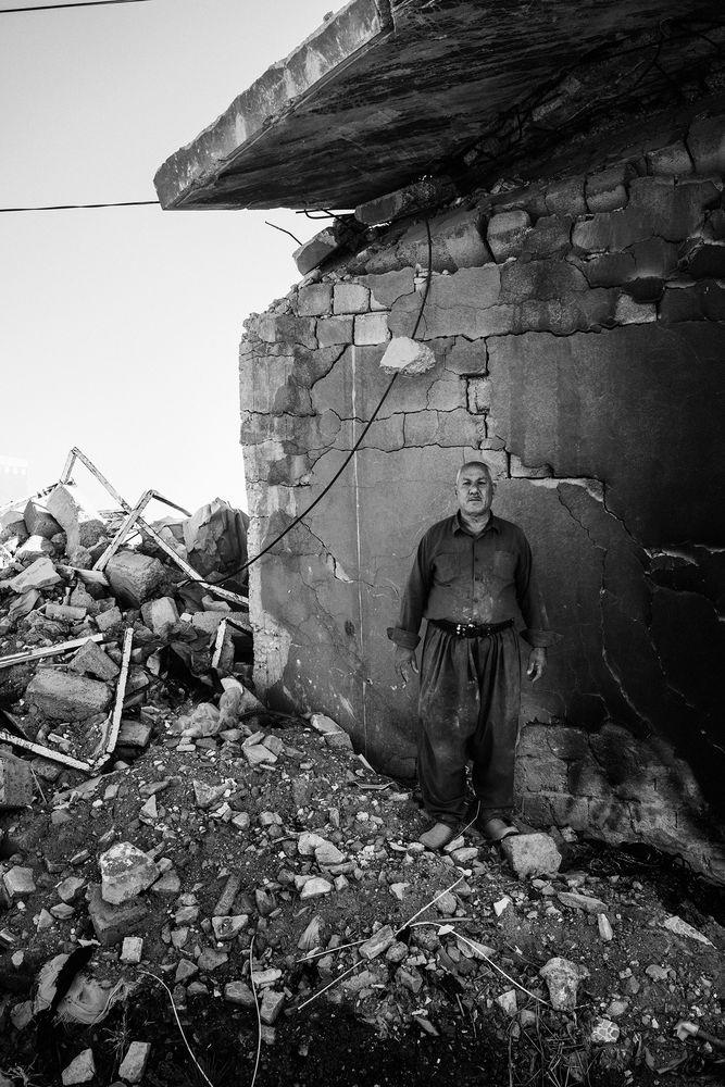 Mohsin Hairan Aswad, 60, a wealthy Yazidi Kurd from Bashiqa, stands in the remains of one of the seven homes that he owns. His homes were destroyed during the fighting to liberate the town from ISIS control in 2016. The next year, his son Faris, a local policeman in Mosul, was killed by an ISIS sniper. | Moises Saman—Magnum Photos for TIME