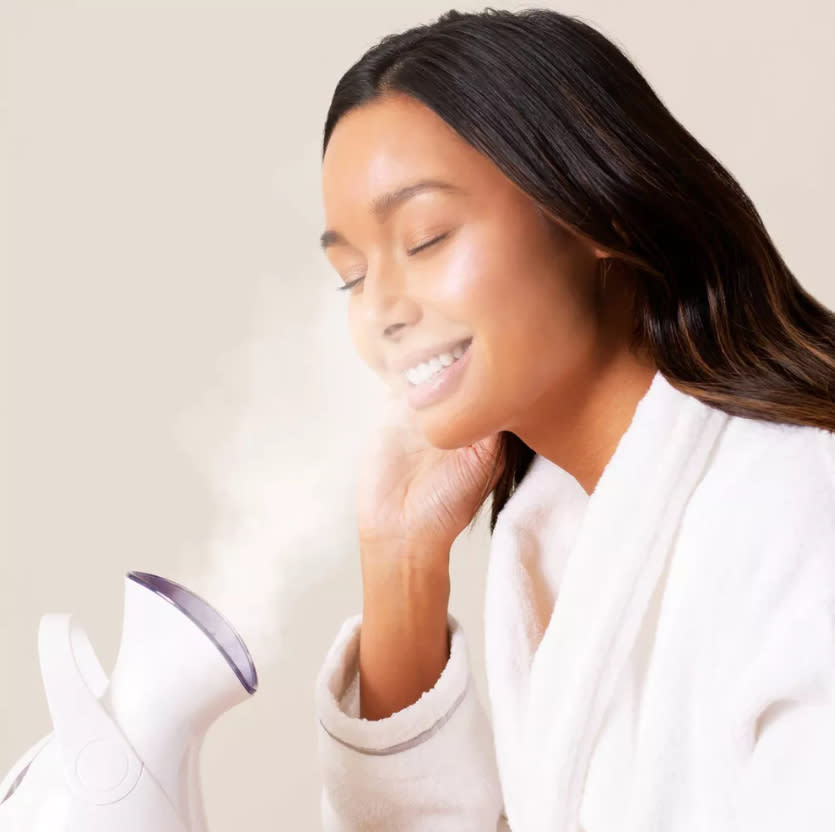 a woman using the face steamer