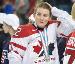 FILE - In this April 4, 2016, file photo, Team Canada's Hayley Wickenheiser wears her silver medal after losing 1-0 to Team USA in the gold medal game at the women's world hockey championships in Kamloops, British Columbia. Regional Olympic officials are rallying around the IOC and have backed its stance on opening the Tokyo Games as scheduled. Their support comes one day after direct criticism from athletes amid the coronavirus outbreak. “I think the IOC insisting this will move ahead, with such conviction, is insensitive and irresponsible given the state of humanity,” said Wickenheiser, a four-time Olympic hockey gold medalist from Canada. (Ryan Remiorz/The Canadian Press via AP, File)