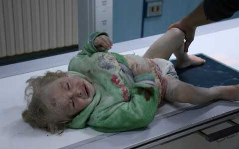 A child injured in an airstrike receives medical treatment at a field hospital after an airstrike in Idlib, Syria - Credit: Getty