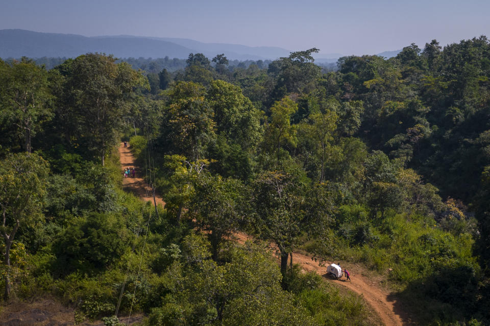 Lata Netam, a health worker, pushes a motorbike ambulance carrying Phagni Poyam and her son, up a steep slope through Abhujmarh, or "the unknown hills," on their way to a health centre, near Kodoli, a remote village in Orchha in central India's Chhattisgarh state, Nov. 15, 2022. These ambulances, first deployed in 2014, reach inaccessible villages to bring pregnant women to an early referral center, a building close to the hospital where expectant mothers can stay under observation, routinely visit doctors if needed until they give birth. Since then the number of babies born in hospitals has doubled to a yearly average of about 162 births each year, from just 76 in 2014. The state has one of the highest rates of pregnancy-related deaths for mothers in India, about 1.5 times the national average, with 137 pregnancy related deaths for mothers per 100,000 births. (AP Photo/Altaf Qadri)