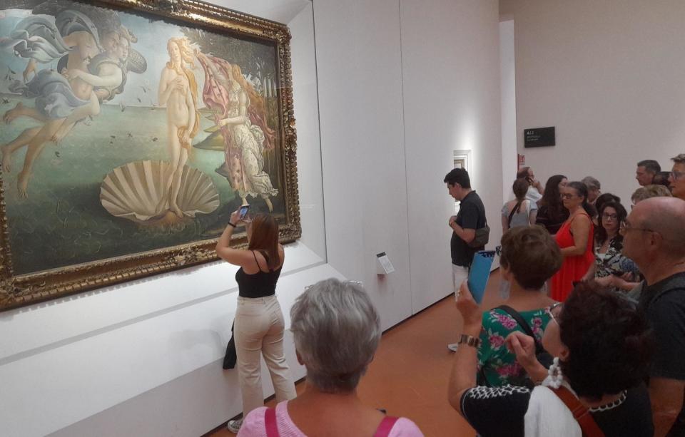 A woman in everyone's way while looking at a painting