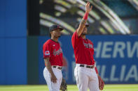 Cleveland Guardians' Gabriel Arias, right, waves to the crowd as Jose Tena, left, stands by after a baseball game against the Texas Rangers in Cleveland, Sunday, Sept. 17, 2023. (AP Photo/Phil Long)
