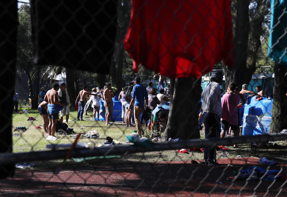 Migrantes centroamericanos hacen fila delante de tanques de agua en el estadio Jesús Martínez, en la Ciudad de México, el 6 de noviembre de 2018. (AP Foto/Marco Ugarte)