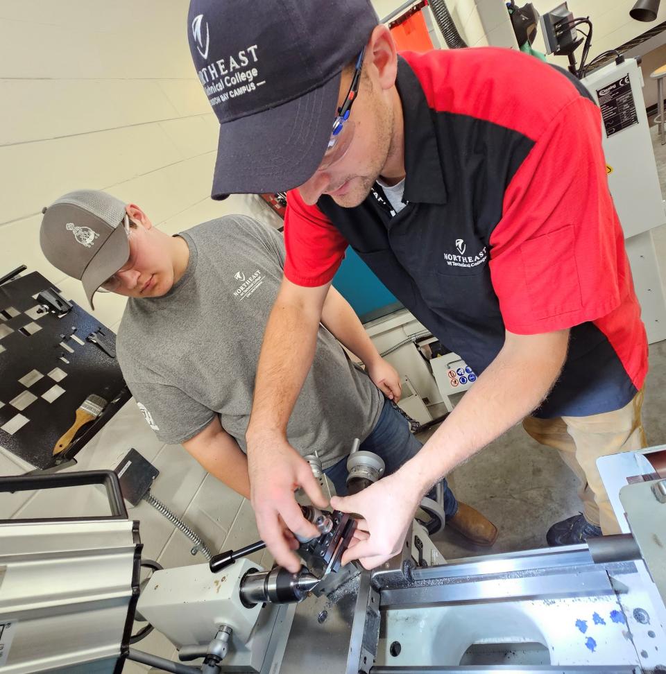 Instructor Garrett Sowl, right, helps student Bradan Wessel of Southern Door High School shape a piece of metal on a lathe in a class for the Door County Machining Program at Sevastopol School.