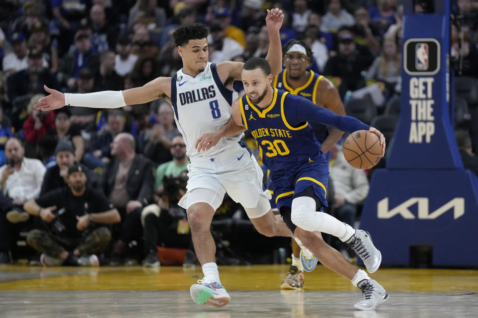 Golden State Warriors guard Stephen Curry (30) brings the ball up the court against Dallas Mavericks guard Josh Green (8) during the second half of an NBA basketball game in San Francisco, Saturday, Feb. 4, 2023. (AP Photo/Jeff Chiu)