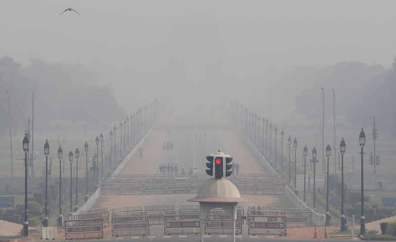 People walk near India Gate on a smoggy afternoon in New Delhi