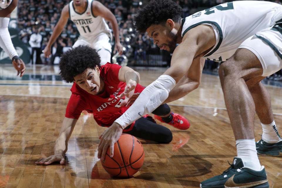 Rutgers guard Derek Simpson, left, dives for the ball after losing it on a drive against Michigan State forward Malik Hall, right, during the first half of an NCAA college basketball game, Sunday, Jan. 14, 2024, in East Lansing, Mich. (AP Photo/Al Goldis)