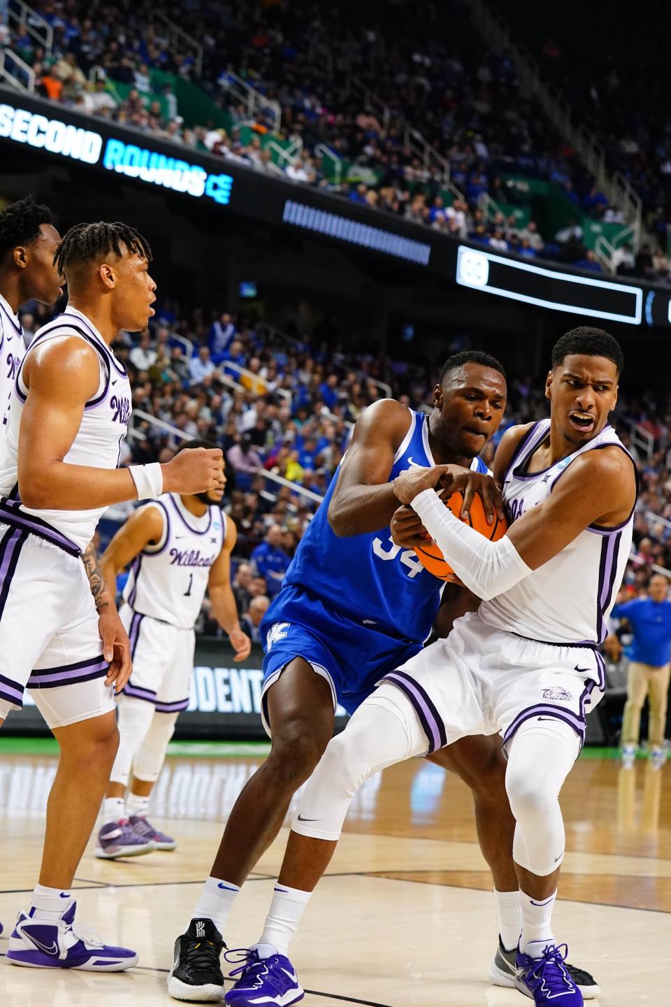 Kentucky forward Oscar Tshiebwe (34) and Kansas State's David N'Guessan battle for a rebound in the first half of their second-round NCAA game Sunday at Greensboro Coliseum.