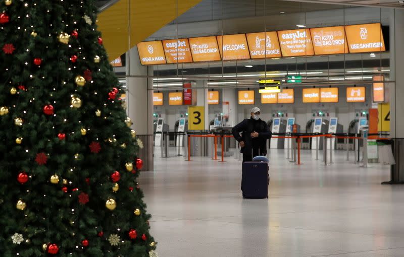 A passenger stands in an almost empty check-in area at Gatwick Airport, amid the coronavirus disease (COVID-19) outbreak, in Crawley