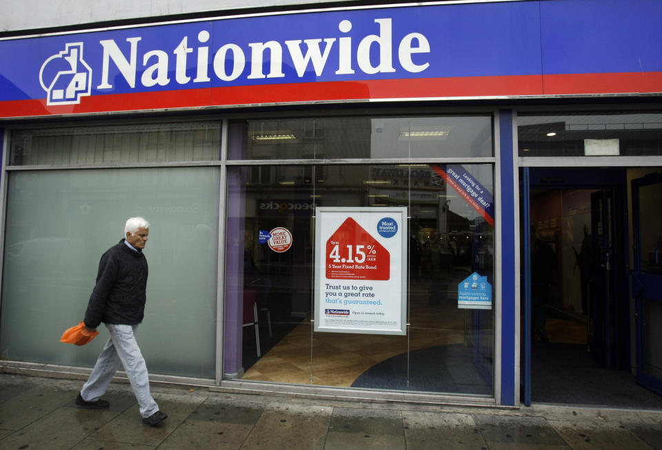 A man walks past a branch of the Nationwide Building Society in Tooting, south London, Wednesday May 27, 2009.  The Nationwide Building Society, a major U.K. mortgage lender, reported Wednesday that its full-year profit fell by 67 percent as earnings were hit by write downs for bad loans and a contribution to the government's insurance plan.  (AP Photo/Matt Dunham)