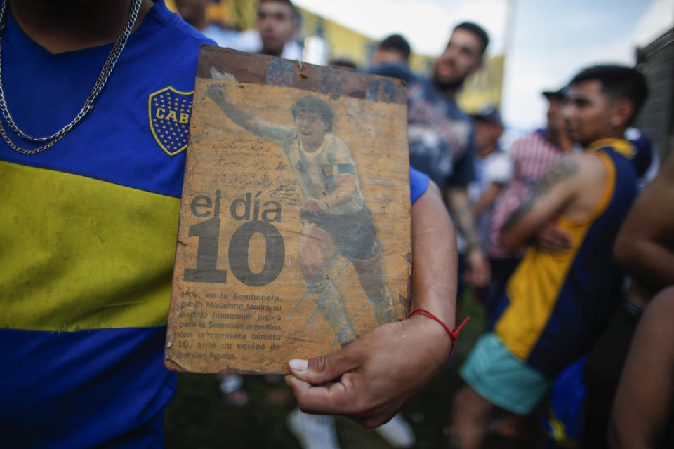 Neighbors gather in front of the house where Diego Maradona was born in the Villa Fiorito neighborhood of Buenos Aires, Argentina, Wednesday, Nov. 25, 2020. The Argentine soccer great who was among the best players ever and who led his country to the 1986 World Cup title before later struggling with cocaine use and obesity, died from a heart attack on Wednesday at his home in Buenos Aires. He was 60.(AP Photo/Natacha Pisarenko)