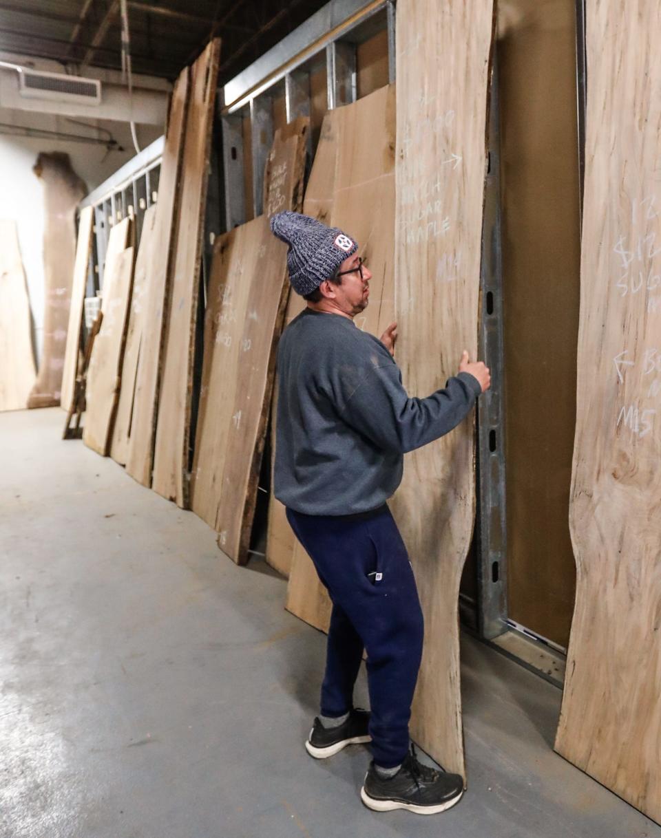 Brian Presnell, owner of Indy Urban Hardwood, looks over large wooden slabs harvested from the Virginia B. Fairbanks Art & Nature Park at the Indianapolis Museum of Art on Tuesday, March 8, 2022, at Indy Urban Hardwood in Indianapolis. The harvested trees will be used to make an array of furniture and other wooden items for the IMA.