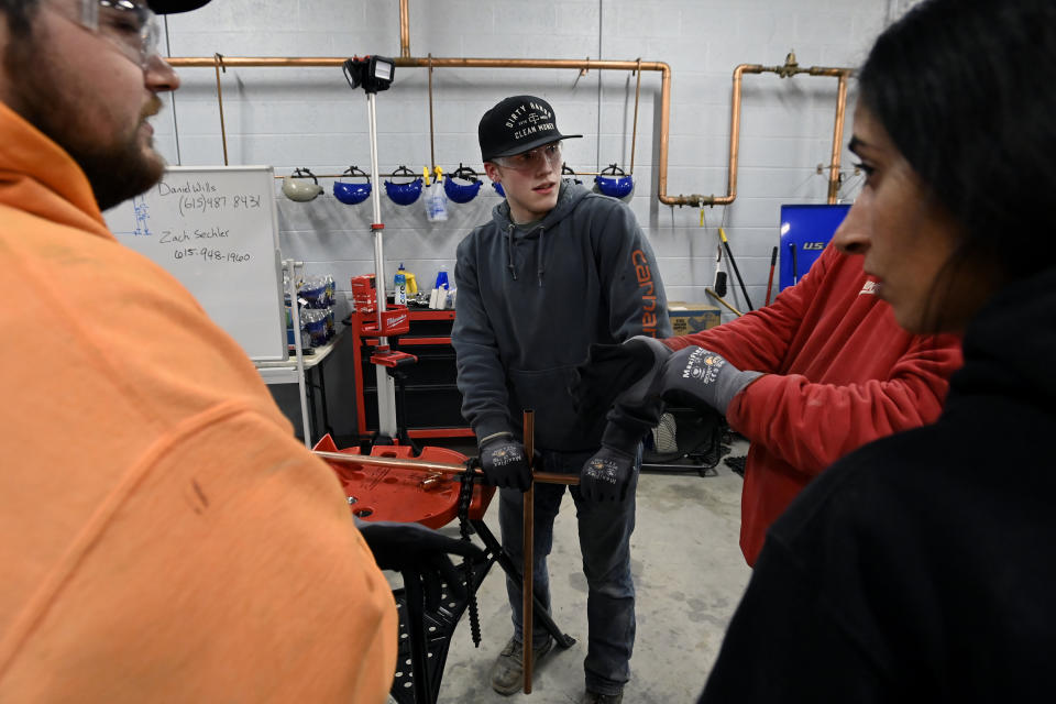 Boone Williams, 20, center, talks to other students in the apprentice training program class at the Plumbers and Pipefitters Local Union 572 facility in Nashville, Tenn., on Thursday, Feb. 2, 2023. Williams says eventually he expects to earn far more than friends who took quick jobs after high school. He even thinks he’s better off than some who went to college — he knows too many who dropped out or took on debt for degrees they never used. “In the long run, I’m going to be way more set than any of them,” he says. (AP Photo/Mark Zaleski)