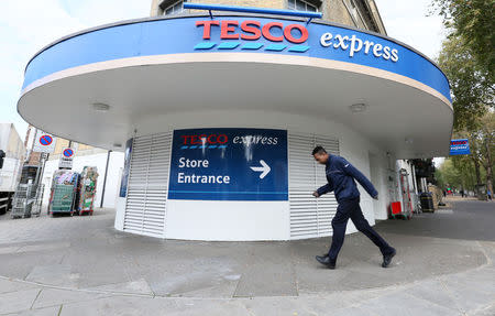 A Tesco employee walks outside a Tesco store in south London October 23, 2014. REUTERS/Paul Hackett