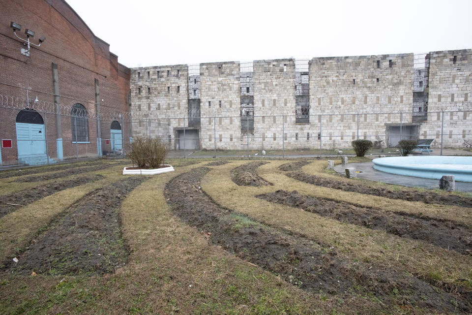 In this Feb. 13, 2020 photo, stone walls of a former cell block stand behind a garden used by inmates at Sing Sing Correctional Facility in Ossining, N.Y. Busting out of Sing Sing has been a dream of inmates since cell doors started clanging shut along the Hudson River in the 1820s. Now there's a plan to usher visitors inside the high walls of the prison famous as a go-to destination for gangsters, Hollywood stars and inmates condemned to the electric chair. (AP Photo/Mark Lennihan)
