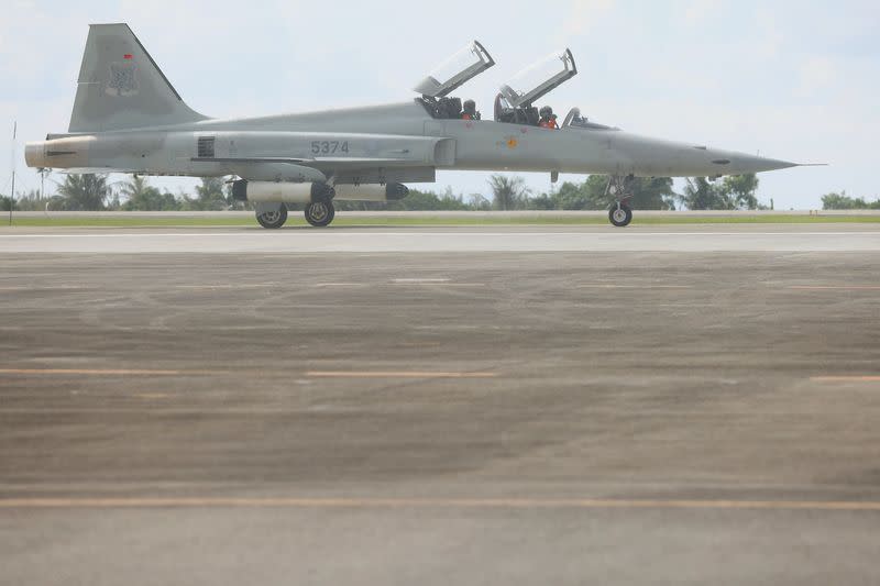 Pilots sit in a F-5 fighter aircraft at an air force base, in Taitung