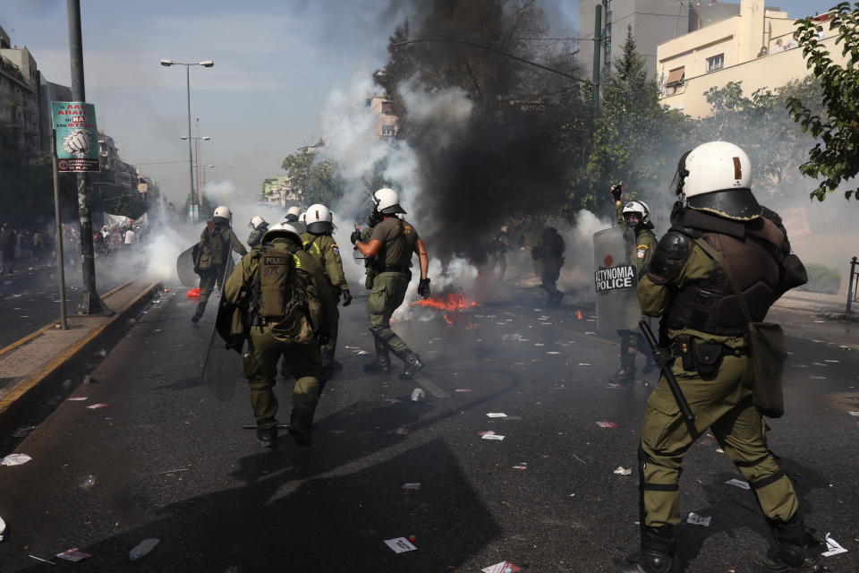 Greek riot police officers charge protesters during scuffles in part of an anti-fascist rally, outside the courthouse in Athens, folloiwng the announcement of its verdict, Wednesday, Oct. 7, 2020. The court ruled that the far-right Golden Dawn party was operating as a criminal organization, delivering a landmark guilty verdict in a marathon five-year trial.The court ruled seven of the party's former lawmakers, including party leader Nikos Michaloliakos, were guilty of leading a criminal organization, while the others were guilty of participating in a criminal organization. .(AP Photo/Yorgos Karahalis)