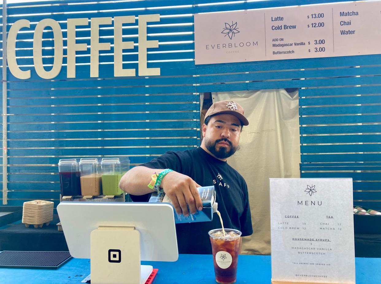 Efrain Mercado, co-owner of Indio's Everbloom Coffee, pours oat milk into a cold brew at Everbloom's stand inside the Indio Central Market at the Coachella Valley Music and Arts Festival.