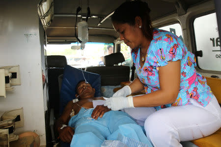 A nurse looks after an injured man after Venezuelan soldiers opened fire on indigenous people near the border with Brazil on Friday, killing two, in Kumarakapay, Venezuela, February 22, 2019. REUTERS/William Urdaneta