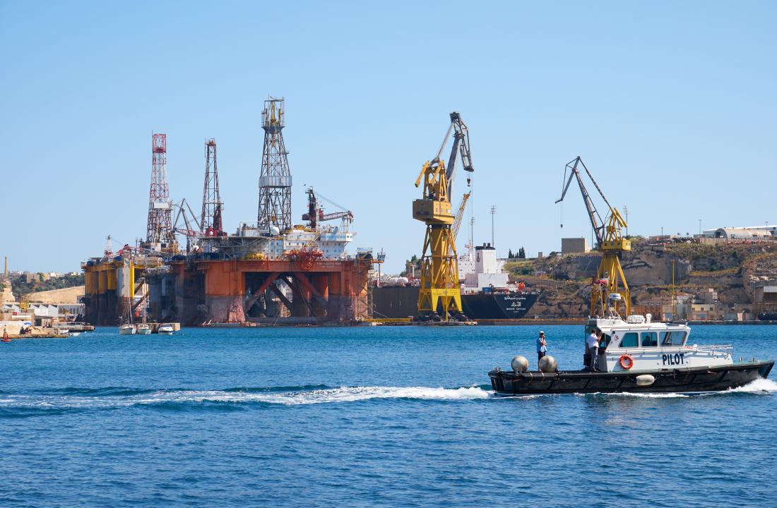Cospicua, MALTA - JULY 24, 2015:  The view of Noble Paul Romano Oil rig in the Palumbo Shipyards with the pilot boat passing by in Cospicua (Bormla),