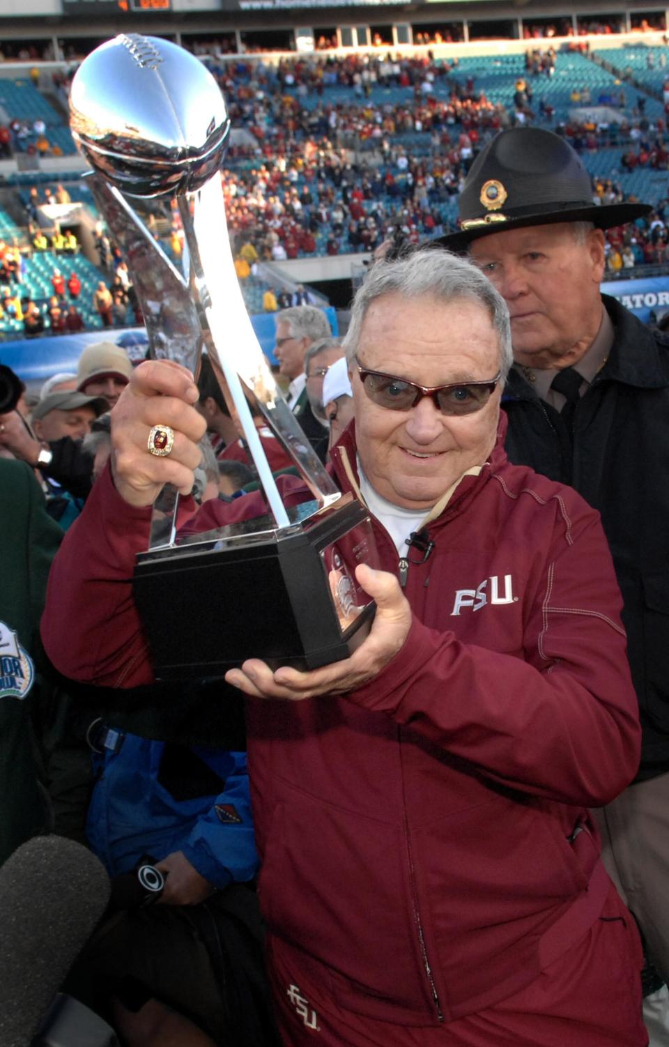 Florida State coach Bobby Bowden hoists the trophy after the Seminoles won the 2010 Gator Bowl over West Virginia, in the final game he coached.