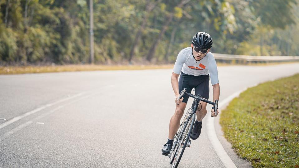 asian chinese professional cyclist athlete sportsman sprinting cycling in rural area