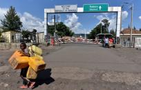 A boy carries jerrycans as he walks past the deserted crossing point between the Democratic Republic of Congo and Rwanda amid concerns about the spread of coronavirus disease (COVID-19), at the Petite Barriere in Goma