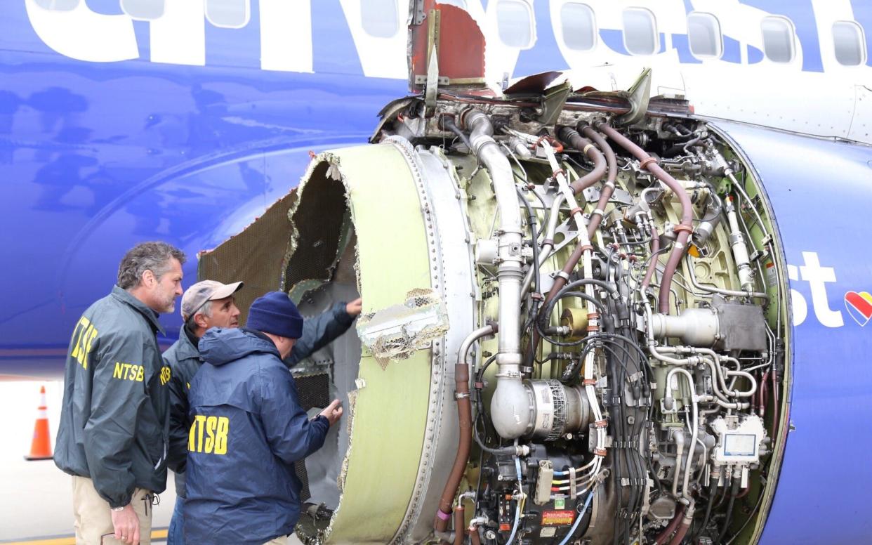 Investigators examine the damage to the engine of the Southwest Airlines plane in Philadelphia - REUTERS