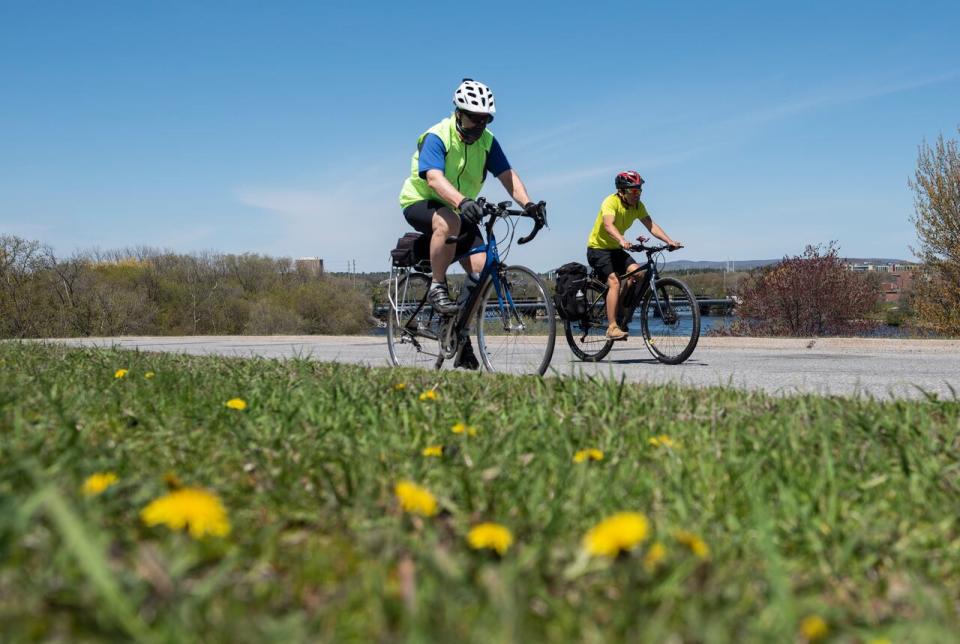 People ride their bikes on the westbound lane of the Sir John A. Macdonald Parkway in Ottawa as it was partially closed to motor vehicle traffic to allow people to get fresh air while practising physical distancing during the COVID-19 pandemic May 18, 2020.