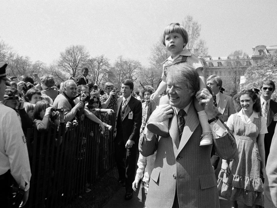 President Jimmy Carter and his grandson, Jason, on his shoulders at the White House Easter Egg Roll in 1977.
