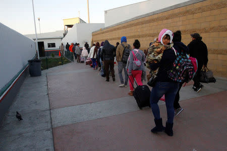 Immigrants from Central America and Mexican citizens, who are fleeing from violence and poverty, queue to cross into the U.S. to apply for asylum at the new border crossing of El Chaparral in Tijuana, Mexico, November 24, 2016. REUTERS/Jorge Duenes