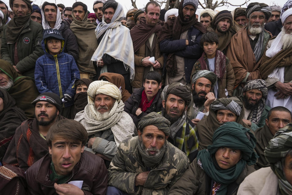 FILE - Hundreds of Afghan men gather to apply for the humanitarian aid in Qala-e-Naw, Afghanistan, on Dec. 14, 2021. As winter deepens, a grim situation in Afghanistan is getting worse. Freezing temperatures are compounding the misery from the downward spiral that has come with the fall of the U.S.-backed government and the Taliban takeover. Aid groups and international agencies estimate about 23 million people, half the country, face severe hunger and nearly 9 million are on the brink of starvation. (AP Photo/Mstyslav Chernov, File)