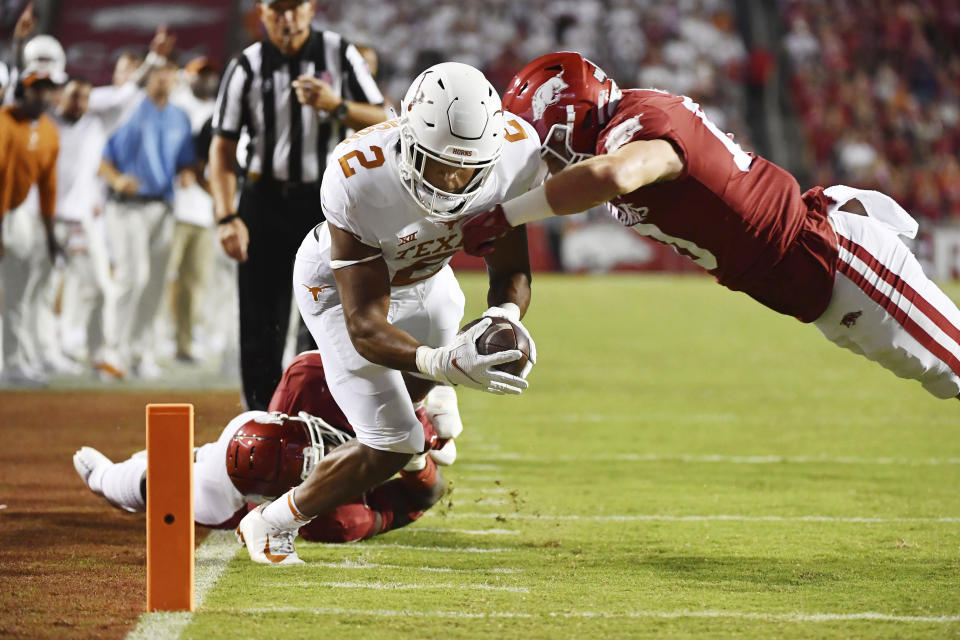 Texas running back Roschon Johnson (2) is knocked out of bounds just short of the end zone by Arkansas defenders Joe Foucha (7) and Bumper Pool (10) during the second half of an NCAA college football game Saturday, Sept. 11, 2021, in Fayetteville, Ark. (AP Photo/Michael Woods)