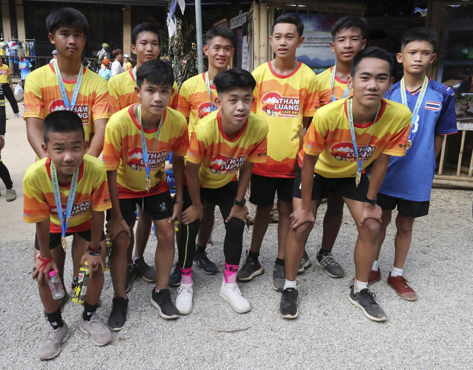 Members of the Wild Boars soccer team who were rescued from a flooded cave, pose for the media after a marathon and biking event in Mae Sai, Chiang Rai province, Thailand, Sunday, June 23, 2019. Some of the 12 young Thai soccer players and their coach have marked the anniversary of their ordeal that saw them trapped in a flooded cave for two weeks with a commemorative marathon in northern Thailand. (AP Photo/Sakchai Lalit)