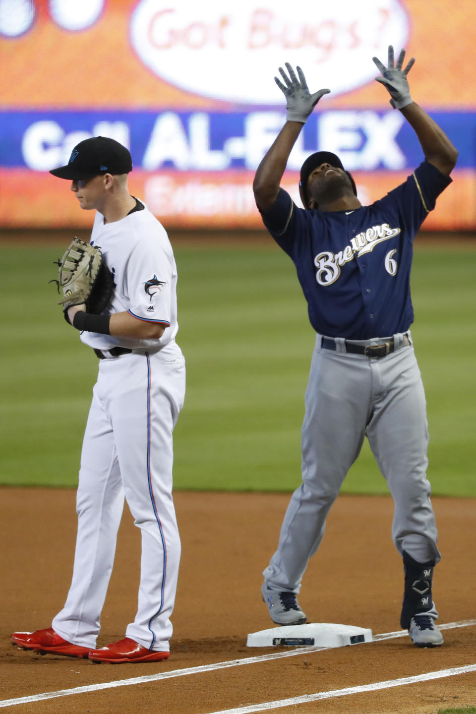 Milwaukee Brewers' Lorenzo Cain (6) celebrates a base hit next to Miami Marlins right fielder Garrett Cooper during the first inning of a baseball game, Thursday, Sept. 12, 2019, in Miami. (AP Photo/Wilfredo Lee)