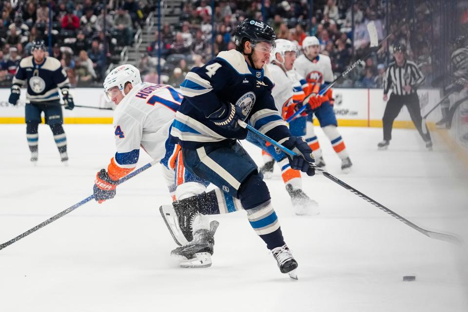 Apr 4, 2024; Columbus, Ohio, USA; Columbus Blue Jackets center Cole Sillinger (4) takes the puck from New York Islanders center Bo Horvat (14) during the second period of the NHL hockey game at Nationwide Arena.
